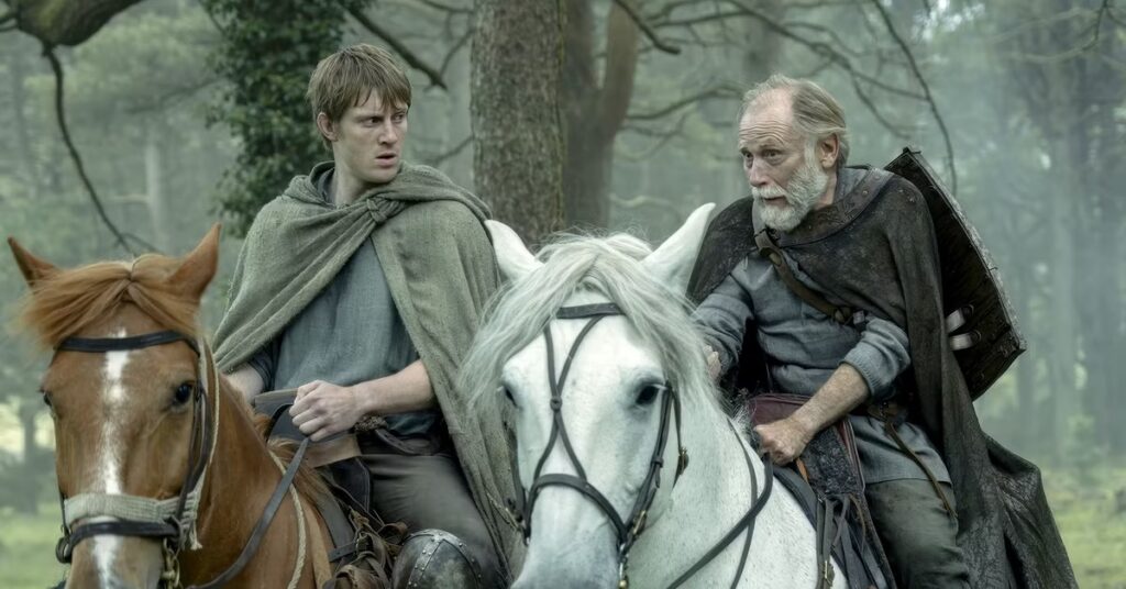 two men, one young, one old, on horseback riding through the woods.