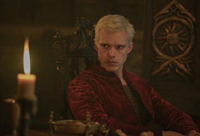 Chàng trai trẻ tóc vàng đẹp trai trong bộ trang phục sang trọng, vẻ mặt u sầu.