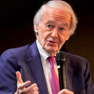 Senator Ed Markey holds a microphone while he speaks at an event.