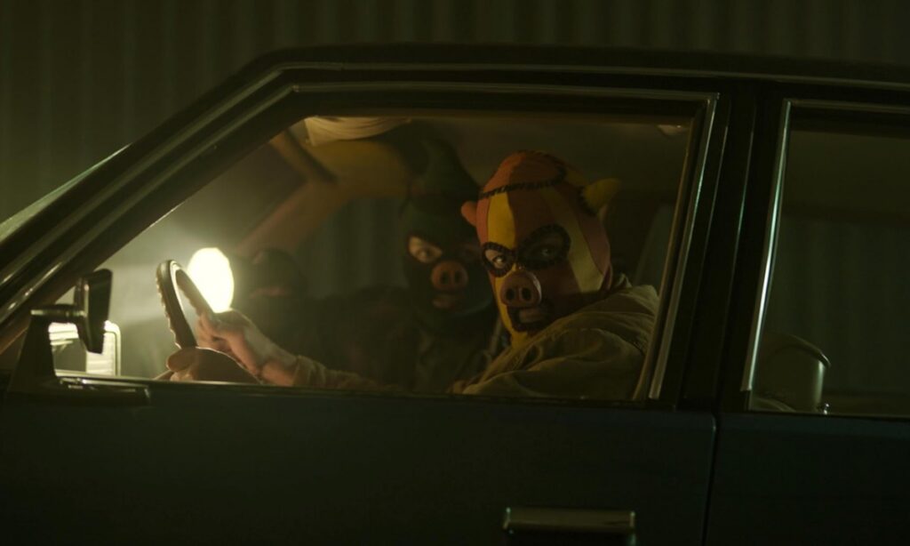 two men in a car wearing pig masks