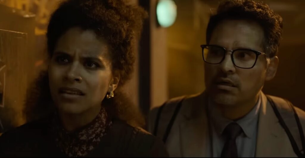 man and a woman looking concerned in a darkened school hallway