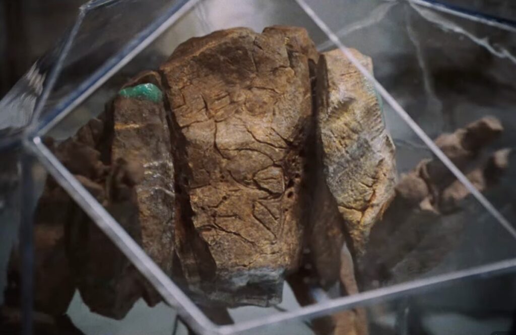 closeup of a small figure made up of rock, with torso and two arms