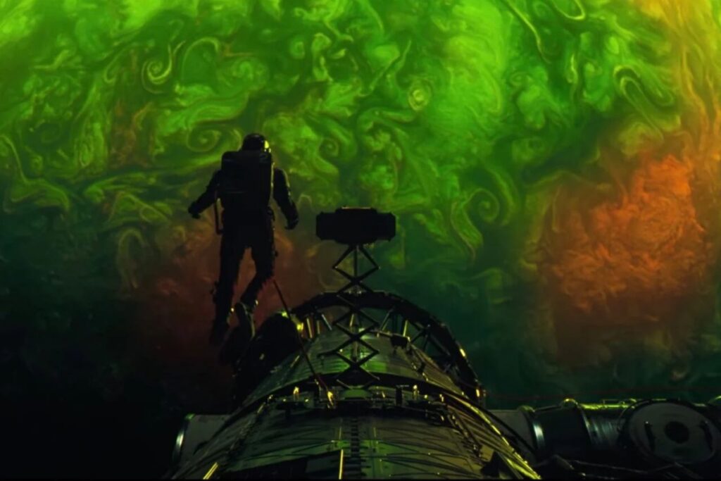 Back view of an astronaut on a space walk moving towards a swirling green cloud