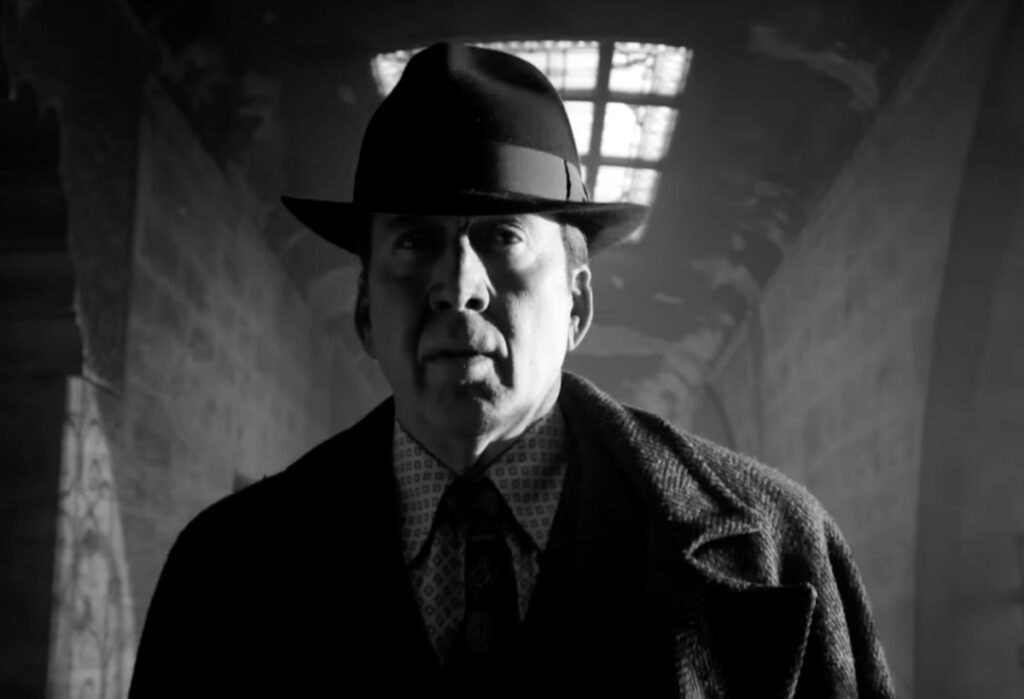 Nicolas Cage in 1930s suit and hat walking down a spooky hallway in Black and White