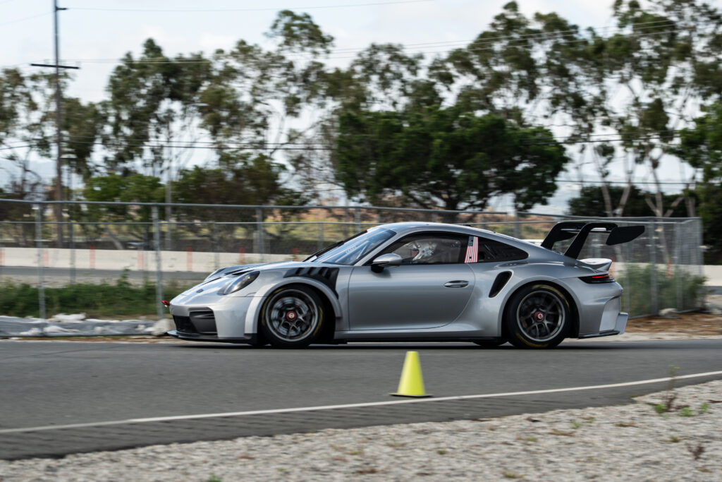 A silver porsche 911 cup car on track