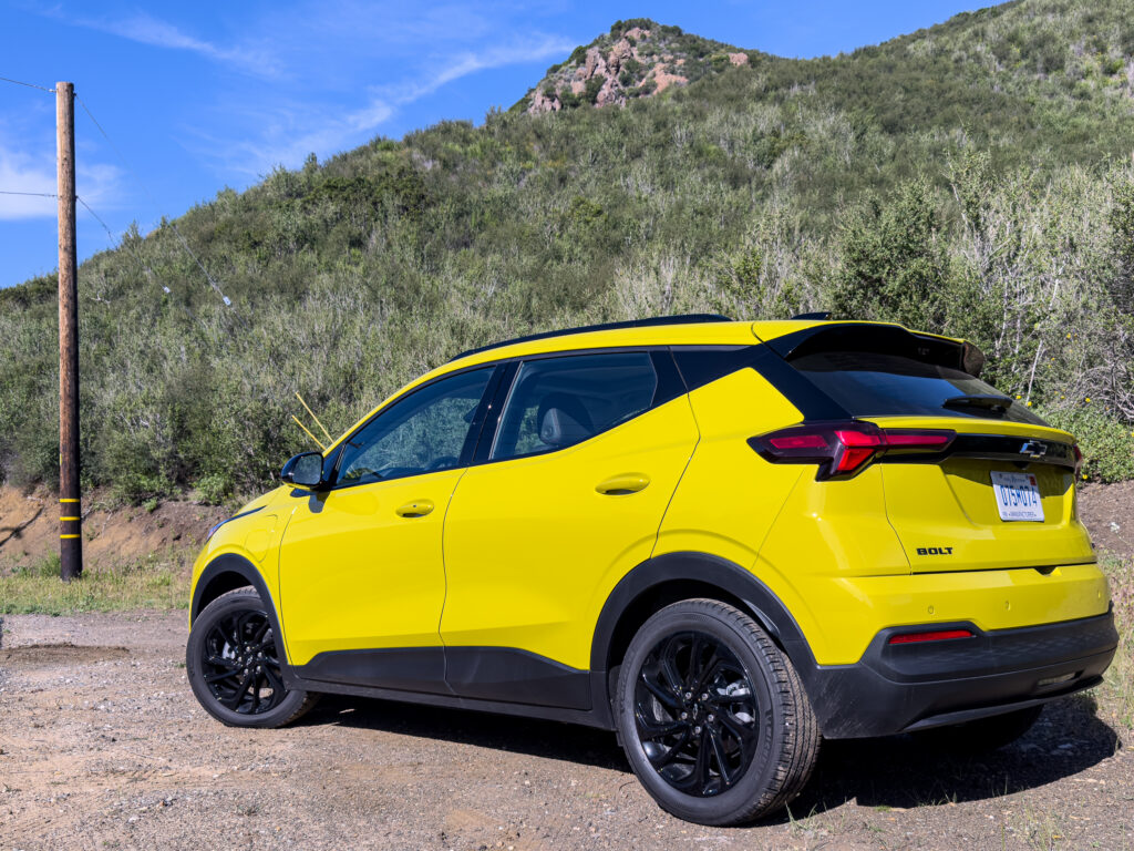A yellow Chevrolet bolt on a back road
