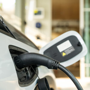 Electric car connected to a charging station, emphasizing modern technology and eco-friendly transportation. Close-up shot in an urban environment with a focus on sustainability and clean energy for a green future.