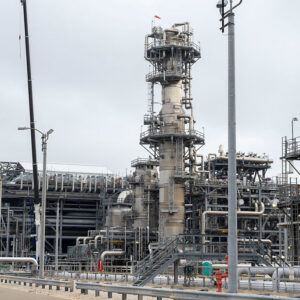 Image of an industrial facility with lots of metal piping against a grey sky.