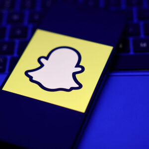 A laptop keyboard and Snapchat logo displayed on a phone screen are seen in this illustration photo taken in Krakow, Poland on February 2, 2026.
