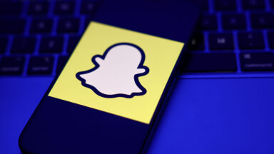 A laptop keyboard and Snapchat logo displayed on a phone screen are seen in this illustration photo taken in Krakow, Poland on February 2, 2026.
