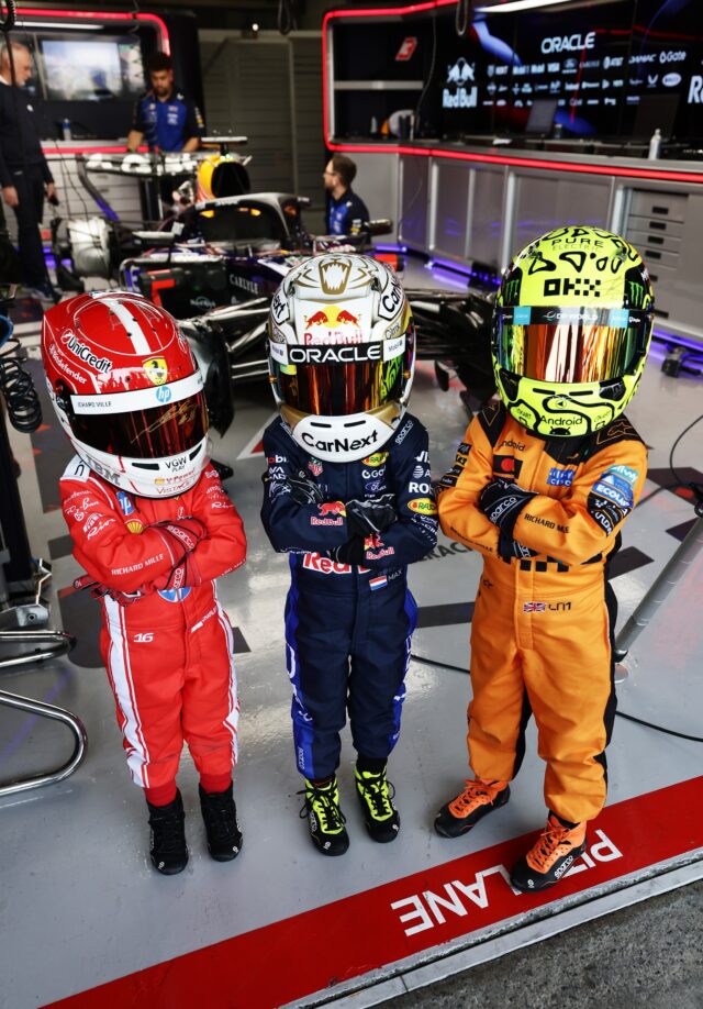 SUZUKA, JAPAN - MARCH 28: Young fans dressed as Lando Norris of Great Britain and McLaren, Max Verstappen of the Netherlands and Oracle Red Bull Racing and Charles Leclerc of Monaco and Scuderia Ferrari pose for a photo in the Oracle Red Bull Racing garage prior to qualifying ahead of the F1 Grand Prix of Japan at Suzuka Circuit on March 28, 2026 in Suzuka, Japan. (Photo by Mark Thompson/Getty Images)