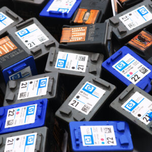 Used Hewlett-Packard black and tri-color printer ink cartridges pile. Some cartridges with visible print heads others with visible label. Cartridges filling entire frame.