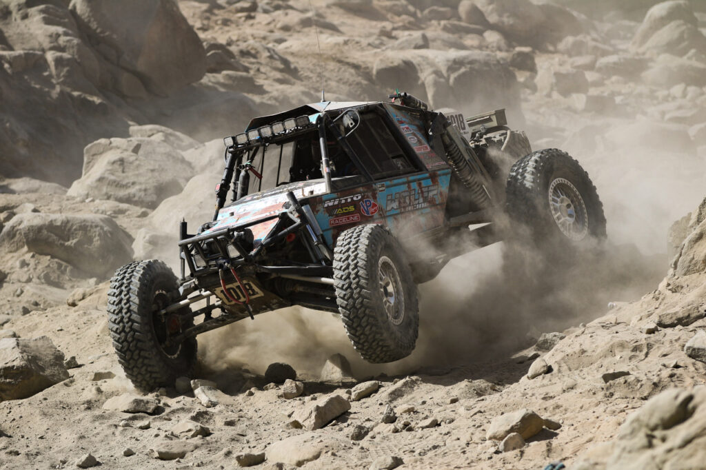 An off-road racing car competes on rough ground
