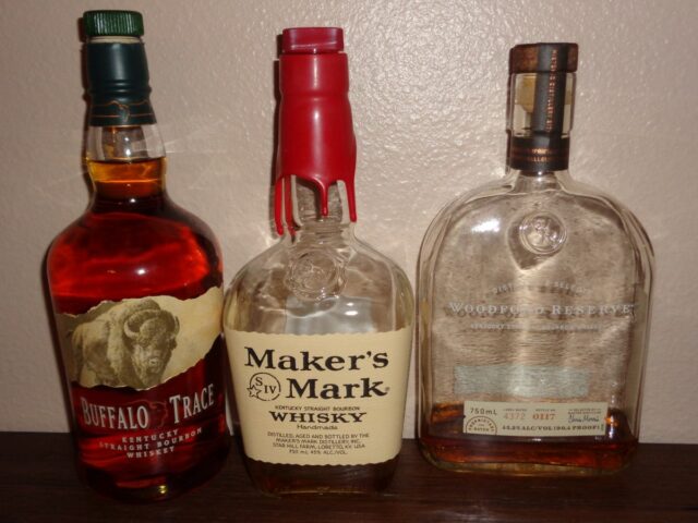 Different brands of Bottles of bourbon: Buffalo Trace (left), Maker's Mark (center), and Woodford Reserve (right)