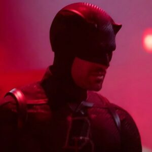 man in daredevil costume against a dimly lit purplish pink background