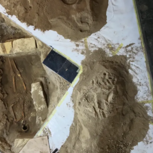 photo of a grave in a church floor, with a skeleton lying in it