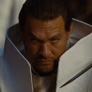 man in white futuristic garb glowering at the camera