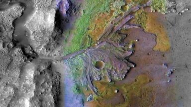 False color image of a crater wall with river delta deposits spreading into the crater from it.