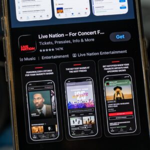 The Live Nation app displayed in an app store on a smartphone. A pair of headphones is shown next to the smartphone.
