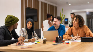 A group of young adults sitting around a table.