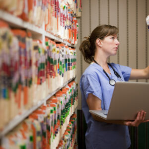 Nurse comparing computer medical records to old paper records.