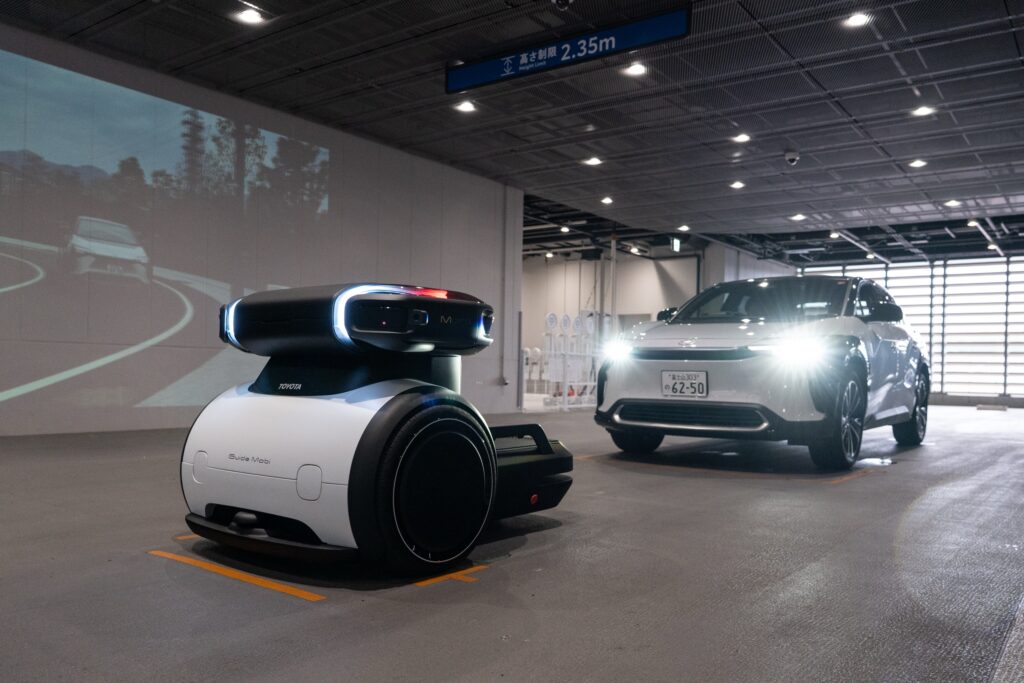 A robot in front of a Toyota ev