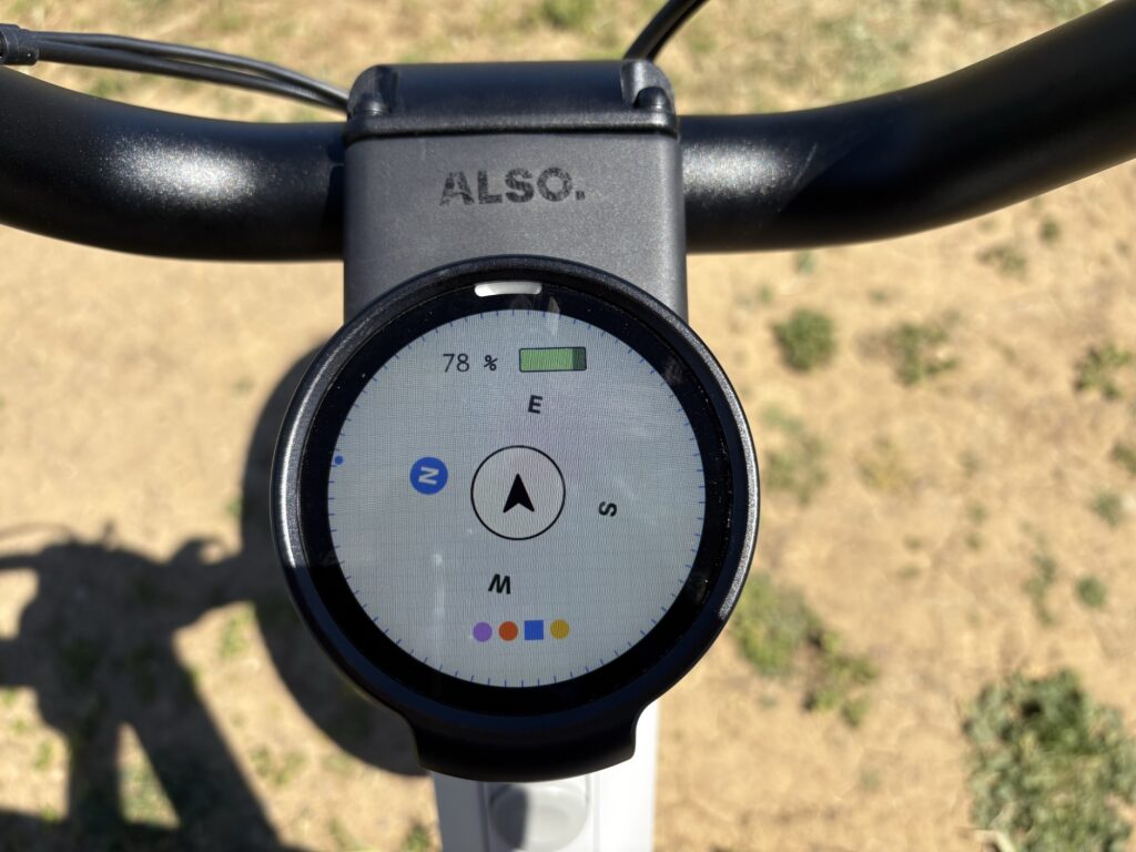 Image of a circular screen centered behind some handlebars. This one shows a compass pointing largely east.