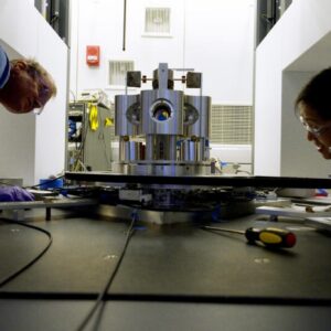 NIST scientists Stephan Schlamminger (left) and Vincent Lee examine the torsion balance they used to measure the gravitational constant, big G, a decade-long undertaking.
