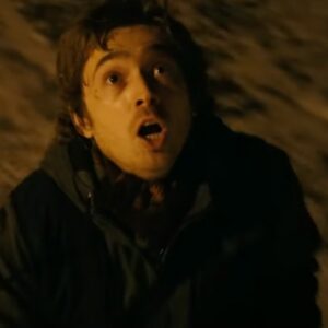 young man looking upward with a look of horror on his face. Late night setting.