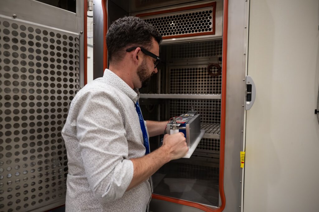 A man puts a battery cell into an oven