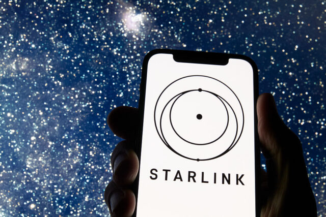The Starlink logo appears on a smartphone screen with a starry night sky in the background.