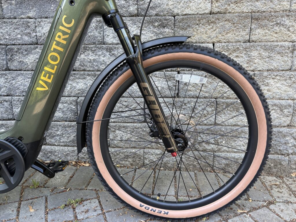 Image of the front wheel of a bicycle, showing forks with a shock absorber.