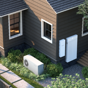 An illustration shows the back of a brown suburban house with an XFRA data center node sitting on the side as a grayish, rectangular box. A grayish-white smart panel and battery, both rectangular, are attached to the back wall of the house.