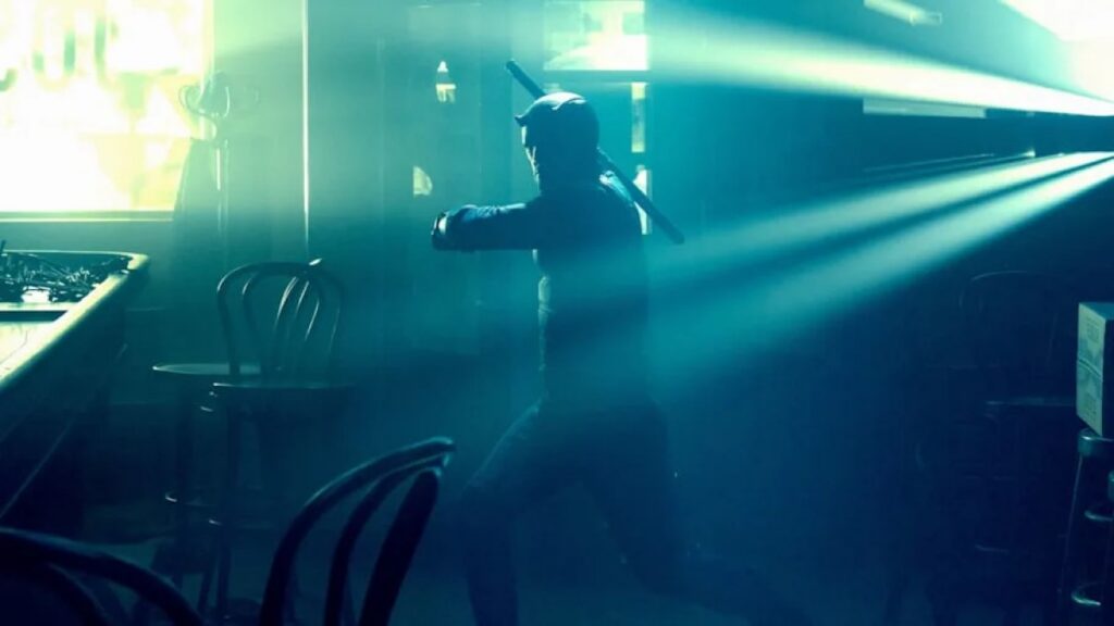 Bullseye backlight in greenish blue hues, poised to throw a makeshift spear in a diner