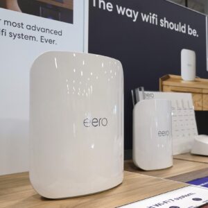 Eero Wi-Fi routers on display inside a store in front of an advertisement that says, "Our most advanced Wi-Fi system, ever."