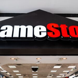 A large GameStop sign hanging above the entrance to a GameStop store inside a mall.