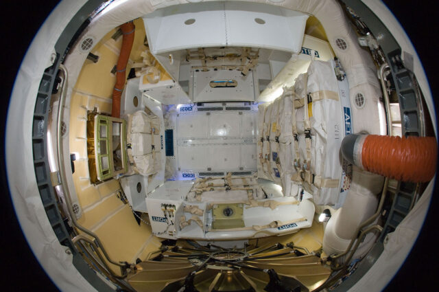 A fish-eye photo looking into a spacecraft's cargo hold.