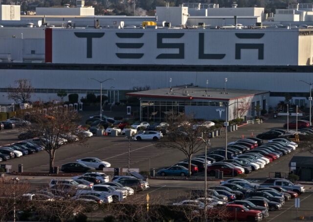 Aerial view of a Tesla factory showing the parking lot and exterior