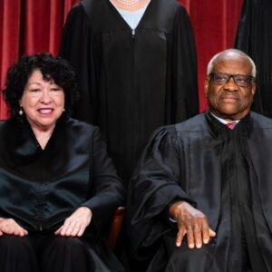 Supreme Court Justices Sonia Sotomayor and Clarence Thomas sitting side by side and wearing their customary court robes.