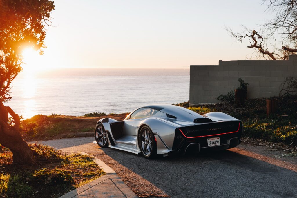 A silver Czinger 21C parked facing the ocean