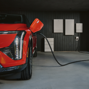 A Cadillac EV in a garage, charging.