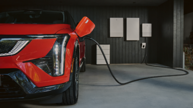 A Cadillac EV in a garage, charging.