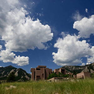 The National Center for Atmospheric Research Mesa Lab seen at a distance beneath a sky full of clouds.
