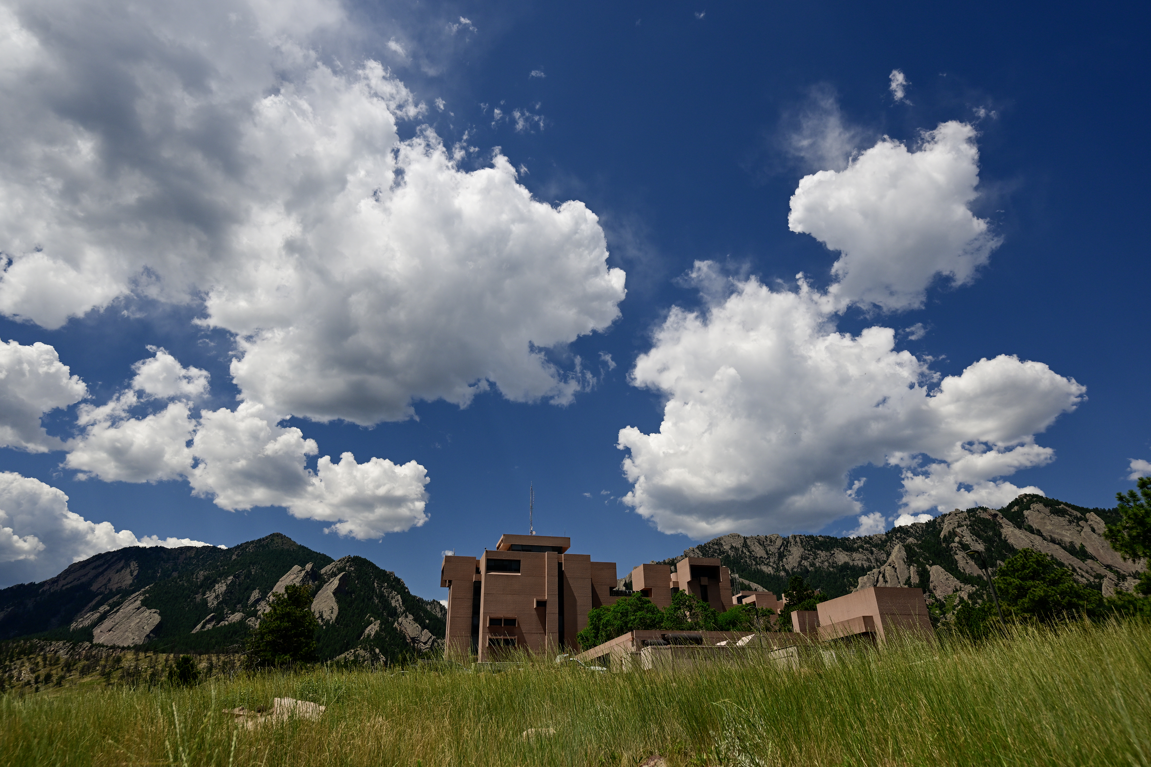 The National Center for Atmospheric Research Mesa Lab seen at a distance beneath a sky full of clouds.
