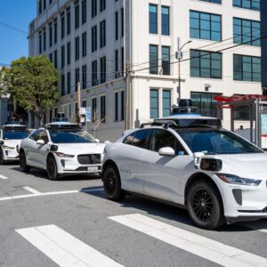 Three Waymo self-driving vehicles drive in a row down a city street in San Francisco, California, March 12, 2026. (Photo by Smith Collection/Gado/Getty Images)