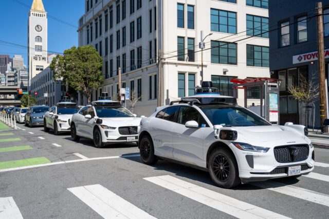 Three Waymo self-driving vehicles drive in a row down a city street in San Francisco, California, March 12, 2026. (Photo by Smith Collection/Gado/Getty Images)