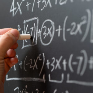 Mathematical operations and algebra mathematic formula written with chalk on the blackboard.