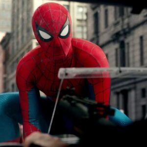 SPider Man in full costume holding onto hood of moving car using webbing