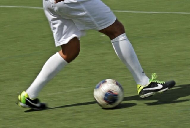 close up of a soccer player's legs on the field as player performs the scissors feint