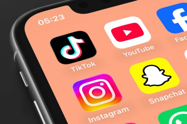 A phone screen displays app icons for TikTok, YouTube, Facebook, Instagram, and Snapchat.